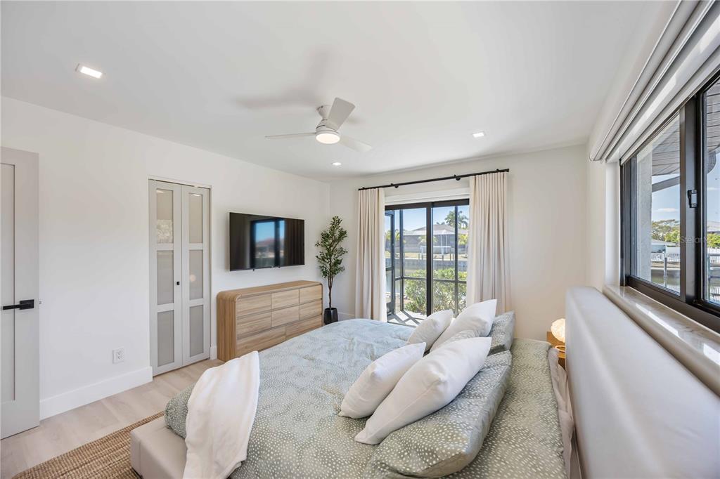 105 Sinclair Street Southeast Port Charlotte, FL 33952 - Photo 31 of 69 a bedroom with a bed and a flat screen tv