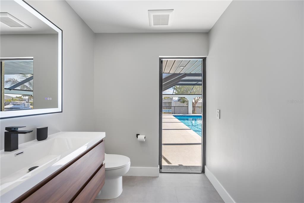 105 Sinclair Street Southeast Port Charlotte, FL 33952 - Photo 37 of 69 a bathroom with a toilet a sink a vanity and mirror