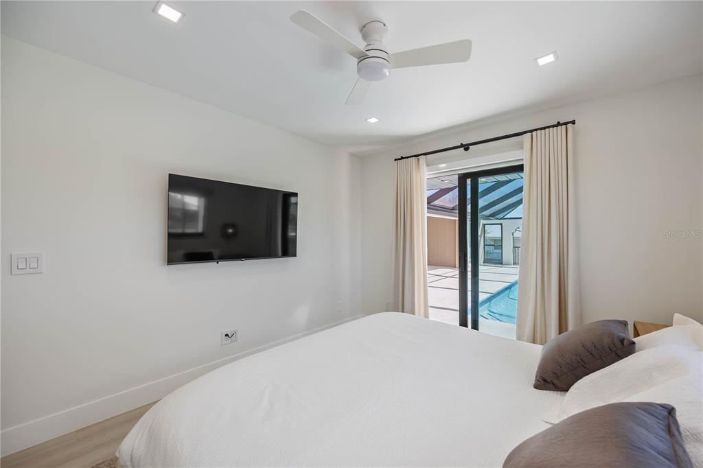 105 Sinclair Street Southeast Port Charlotte, FL 33952 - Photo 41 of 69 a bedroom with a large bed and a flat screen tv