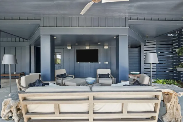 a living room with furniture a flat screen tv and a floor to ceiling window