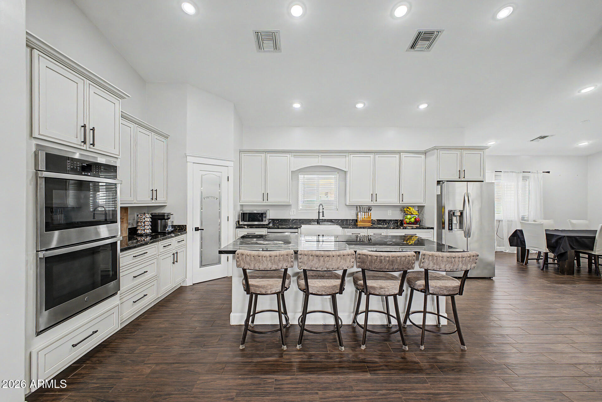 1427 East Whiteley Street Apache Junction, AZ 85119 - Photo 10 of 59 a kitchen with stainless steel appliances kitchen island granite countertop a dining table chairs and refrigerator