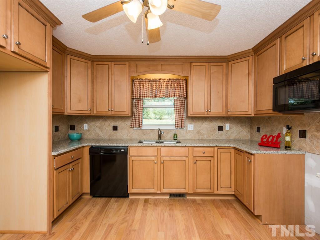 3811 Donna Road Raleigh, NC 27604 - Photo 4 of 25 a kitchen with stainless steel appliances granite countertop wooden cabinets a sink and dishwasher with wooden floor