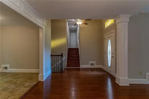 a view of empty room with wooden floor and stairs