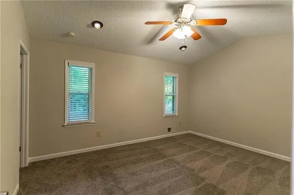 a view of empty room with window and ceiling fan