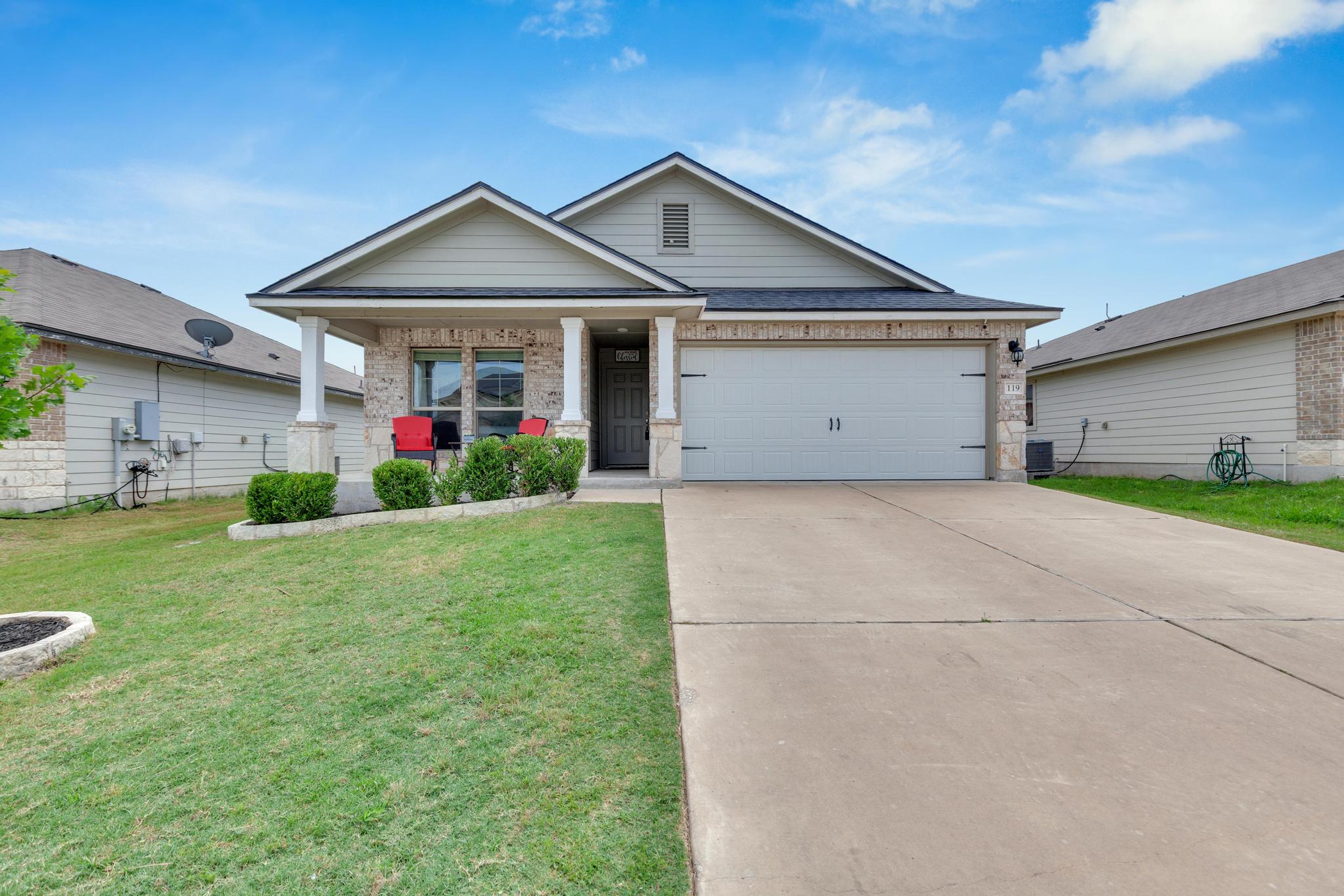 119 Beth Ann Loop Taylor, TX 76574 - Photo 1 of 31 A welcoming facade showcases a well-maintained lawn and an inviting covered porch.