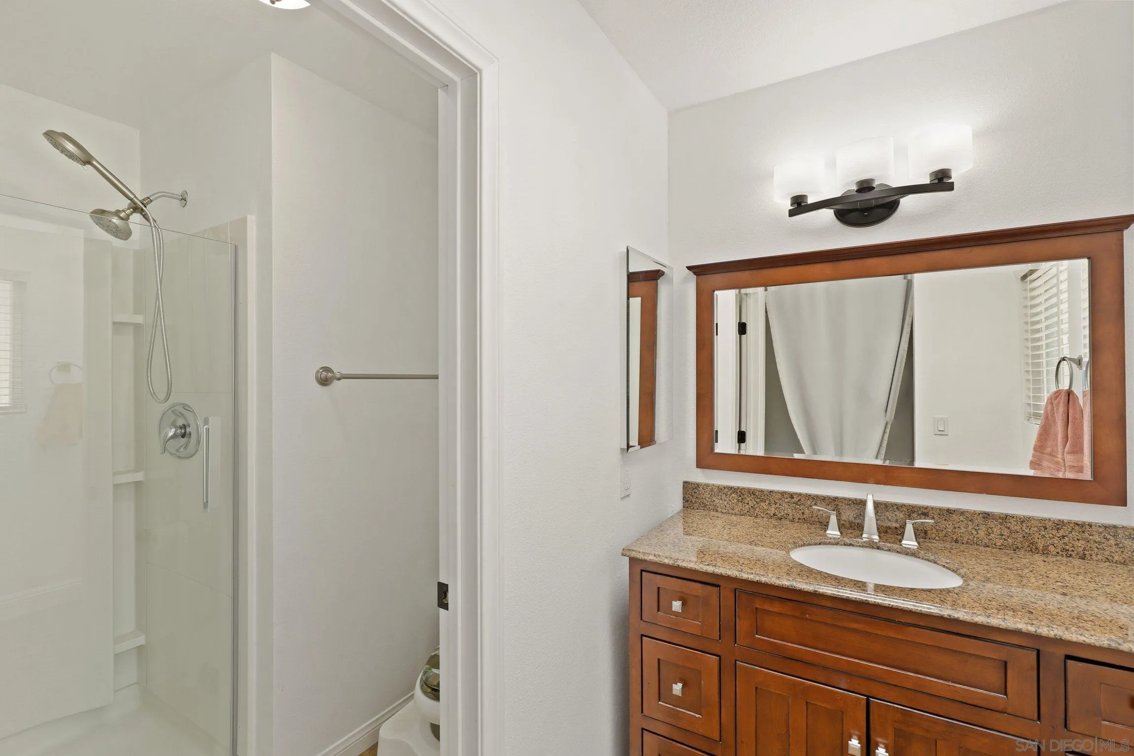 4141 Bryan Street Oceanside, CA 92056 - Photo 14 of 22 a bathroom with a granite countertop sink a mirror and a shower