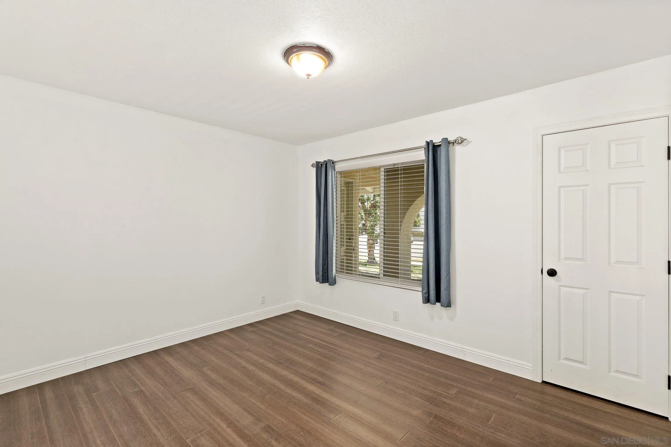 4141 Bryan Street Oceanside, CA 92056 - Photo 15 of 22 an empty room with wooden floor and windows