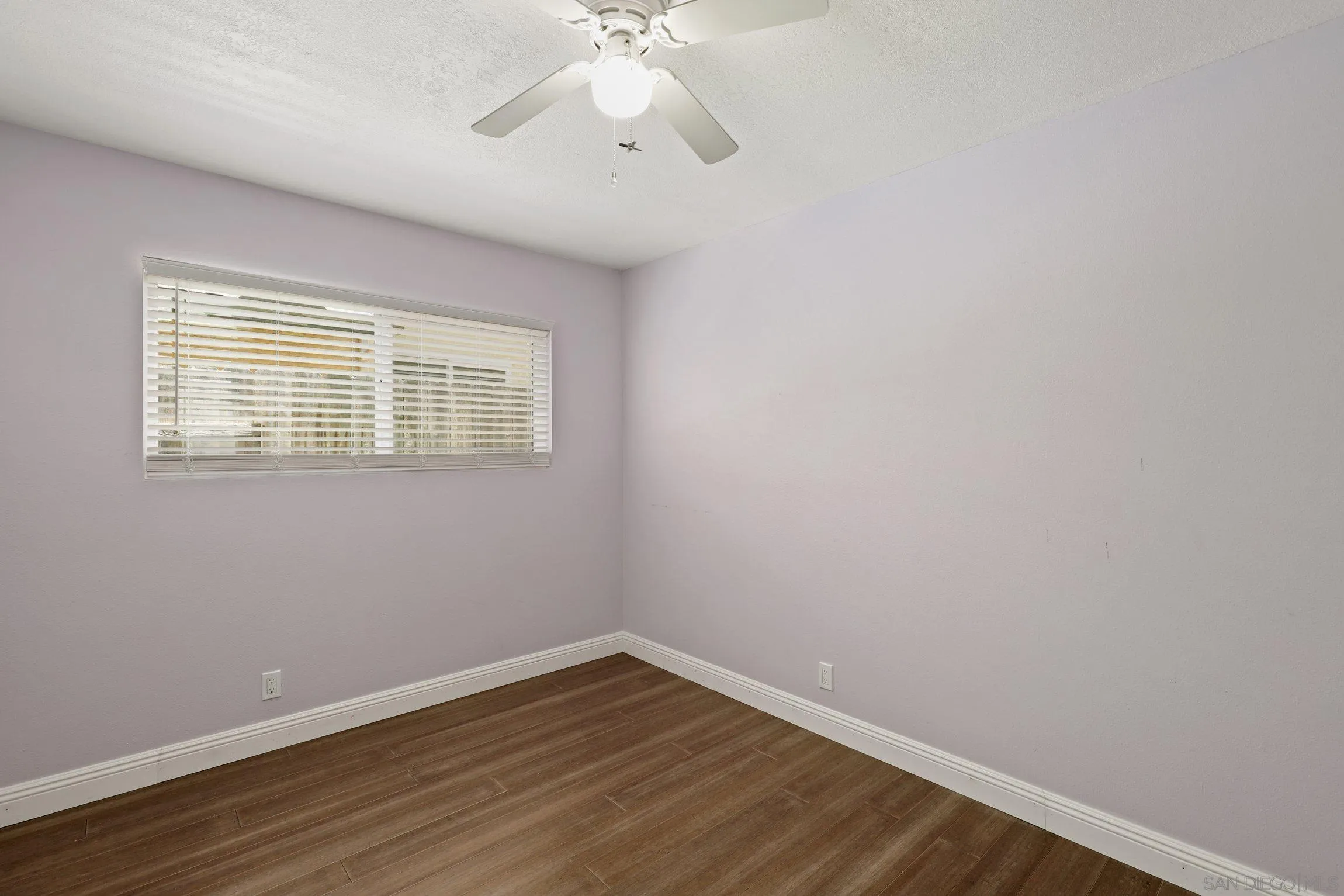 4141 Bryan Street Oceanside, CA 92056 - Photo 16 of 22 a view of an empty room with wooden floor and a window