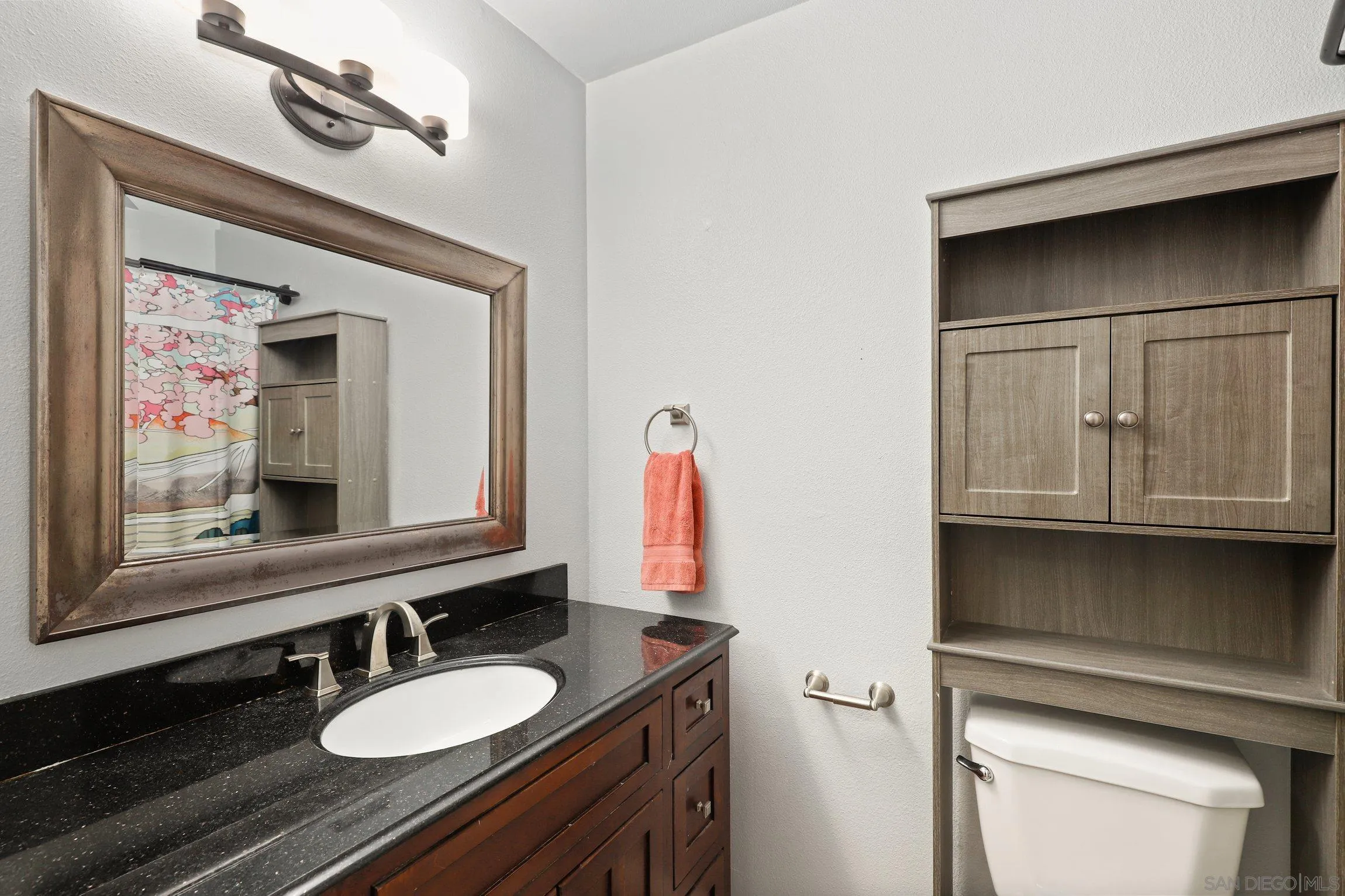 4141 Bryan Street Oceanside, CA 92056 - Photo 17 of 22 a bathroom with a granite countertop sink a mirror and a toilet