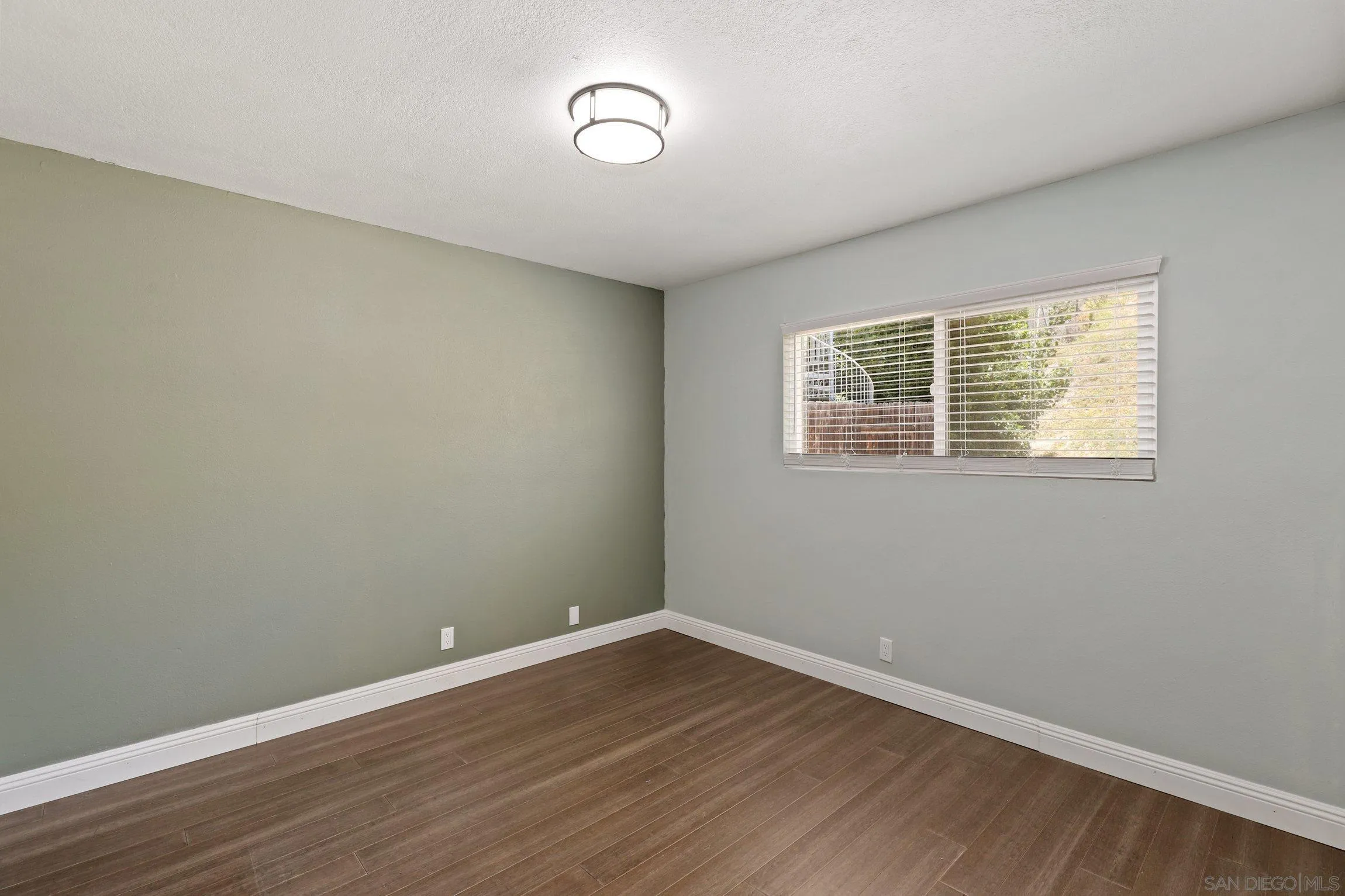 4141 Bryan Street Oceanside, CA 92056 - Photo 18 of 22 a view of an empty room with wooden floor and a window