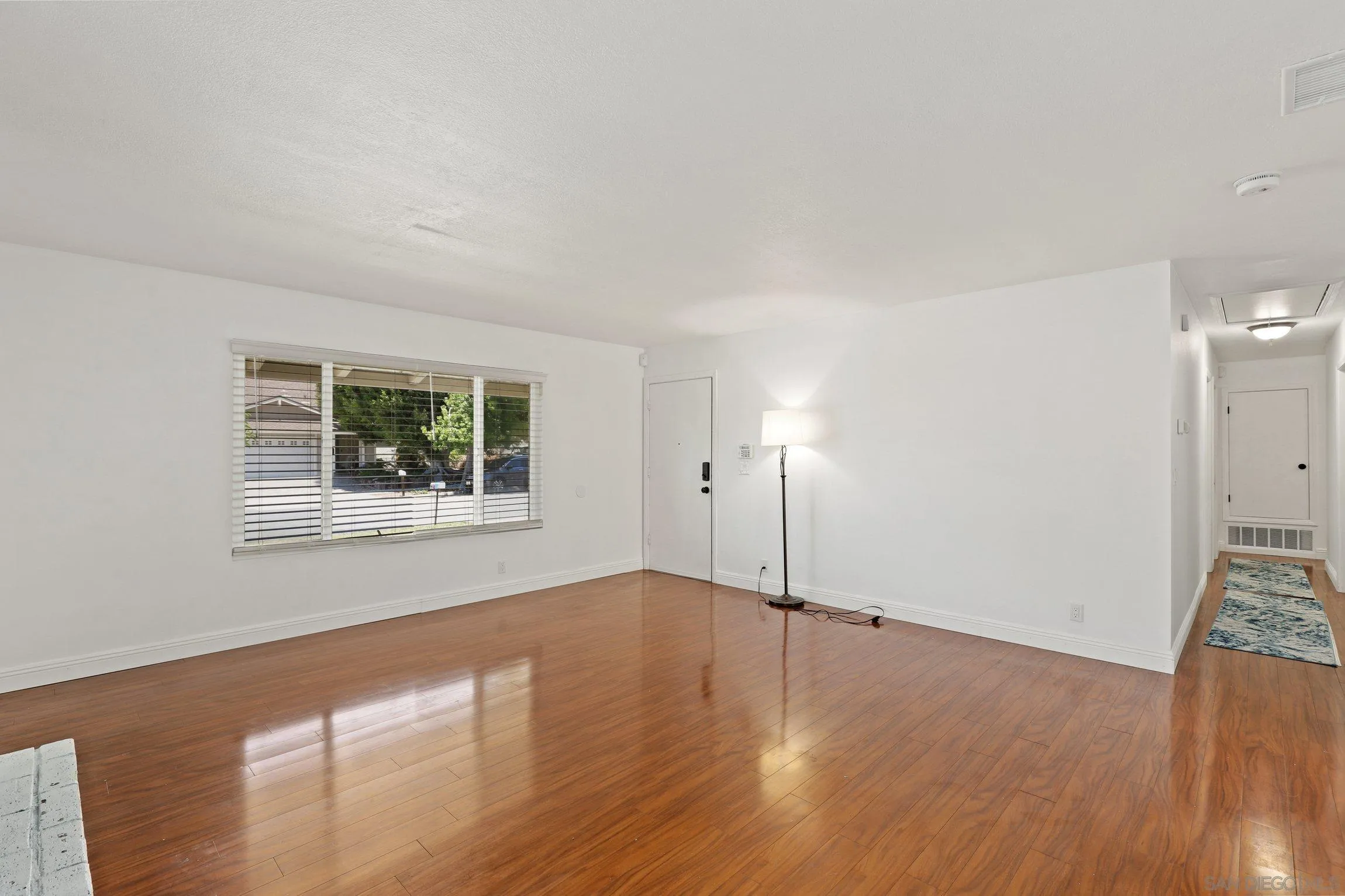 4141 Bryan Street Oceanside, CA 92056 - Photo 6 of 22 a view of an empty room with wooden floor and a window