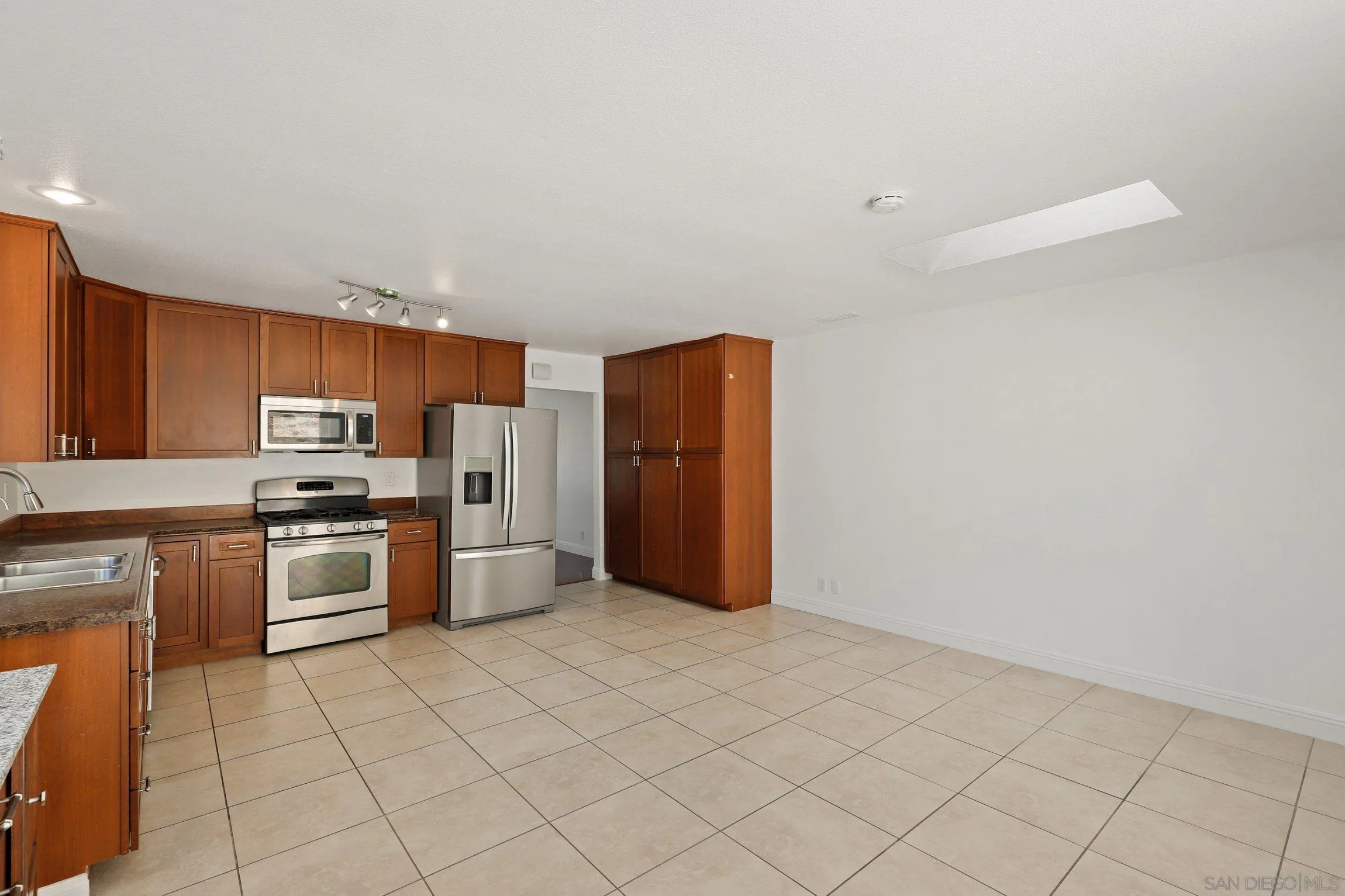 4141 Bryan Street Oceanside, CA 92056 - Photo 9 of 22 a kitchen with granite countertop a refrigerator and a stove top oven