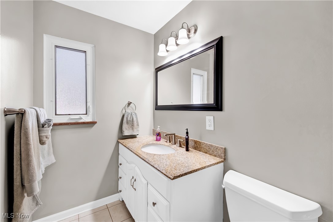 1051 Rockside Road Independence, OH 44131 - Photo 13 of 30 Bathroom with baseboards, vanity, toilet, and tile patterned floors