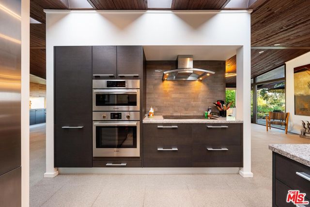 a room with wooden cabinets and stainless steel appliances