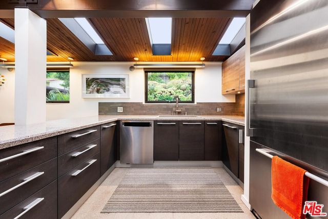 a kitchen with stainless steel appliances granite countertop a sink and a stove