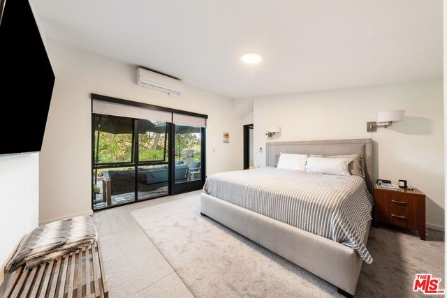 a bedroom with a bed and a large window