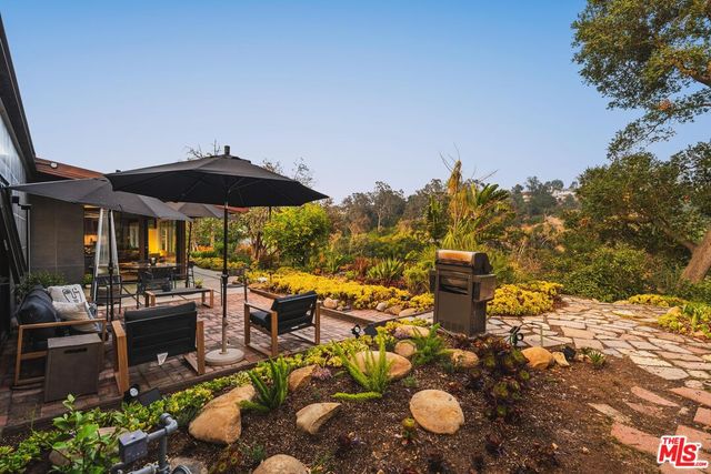 a view of a patio with chairs under an umbrella