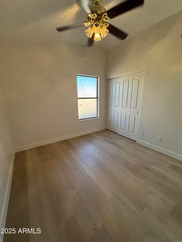 an empty room with a window and a chandelier fan