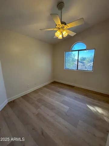 en empty room with window and chandelier fan