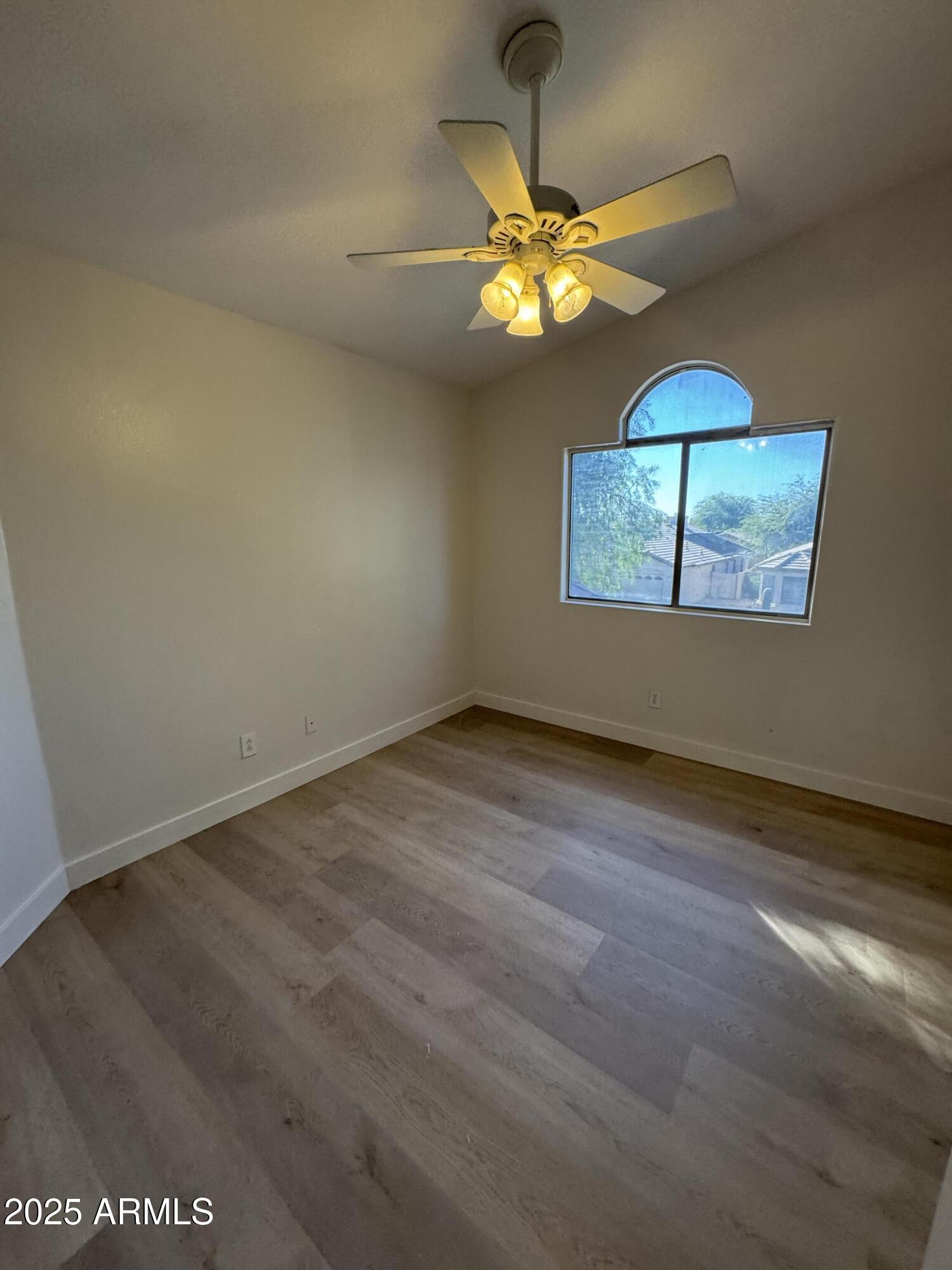 4626 East Weaver Road Phoenix, AZ 85050 - Photo 21 of 21 en empty room with window and chandelier fan