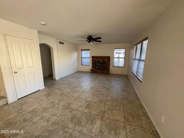 an empty room with windows and a ceiling fan