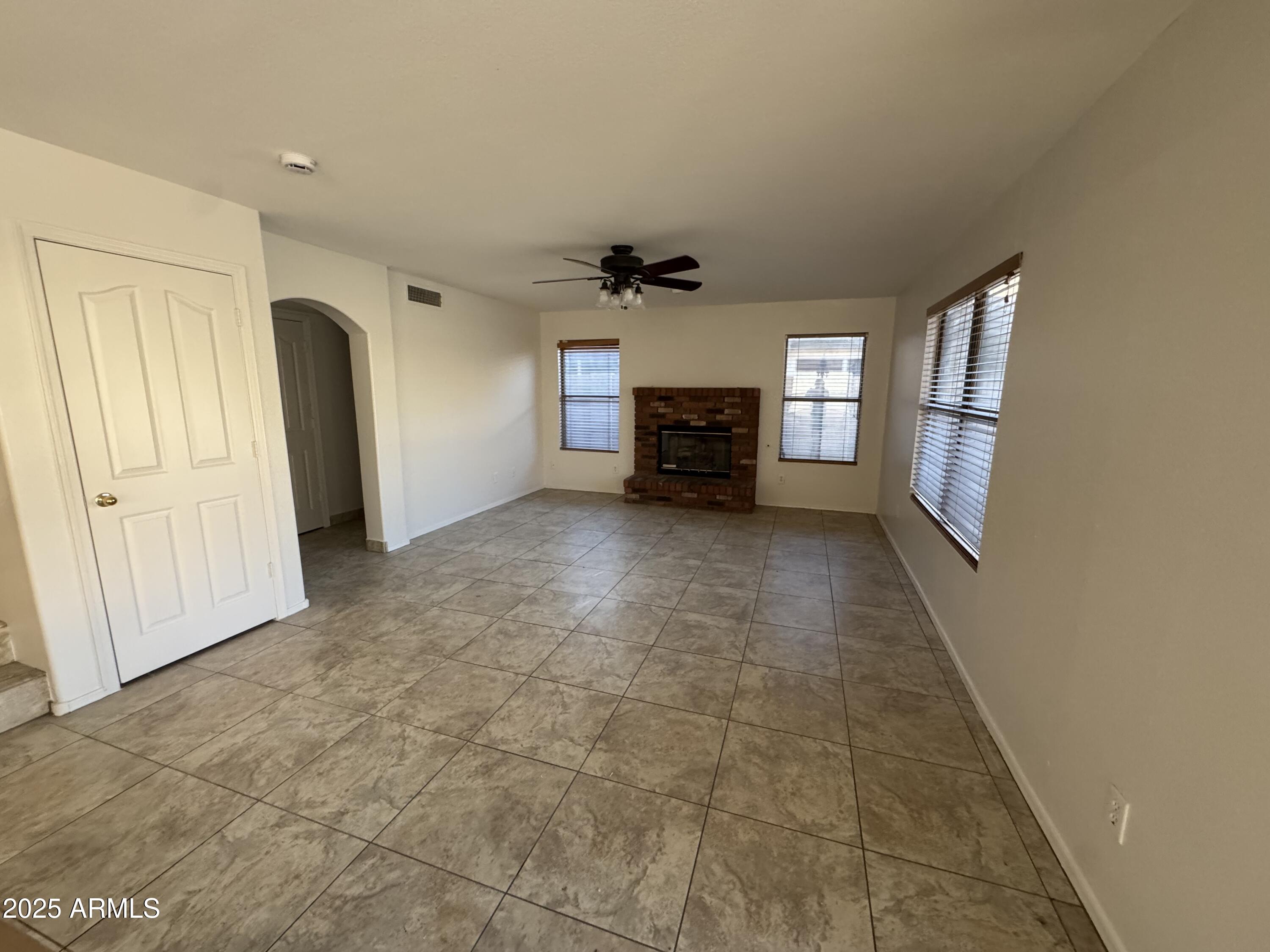 4626 East Weaver Road Phoenix, AZ 85050 - Photo 5 of 21 an empty room with windows and a ceiling fan