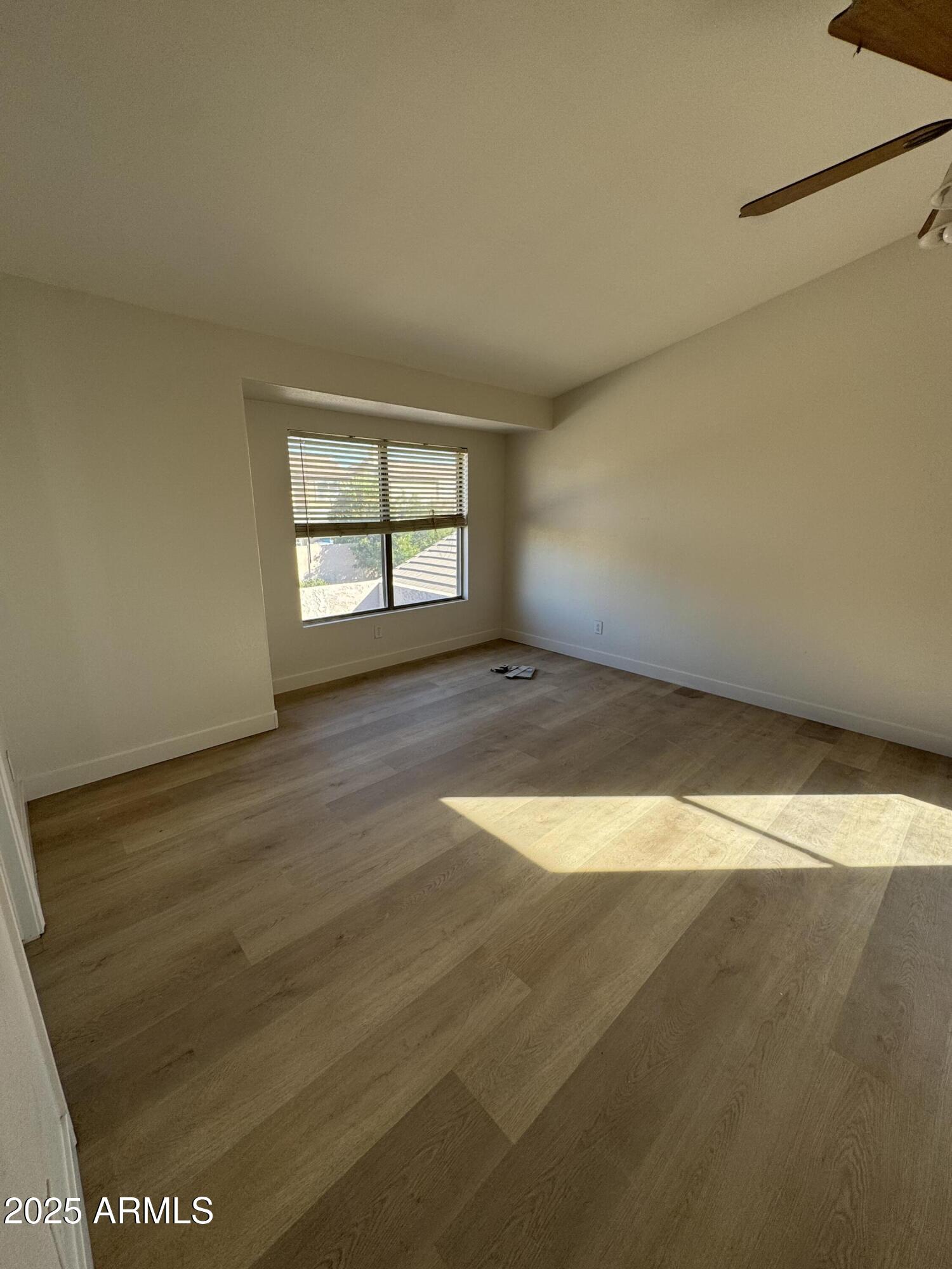 4626 East Weaver Road Phoenix, AZ 85050 - Photo 8 of 21 an empty room with wooden floor and windows