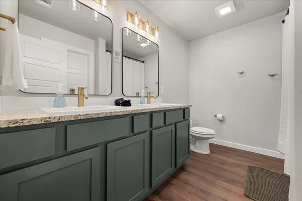 a bathroom with a granite countertop sink mirror and toilet