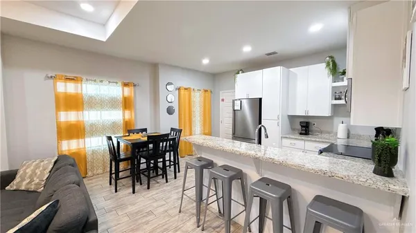 a kitchen with stainless steel appliances granite countertop table chairs sink and cabinets