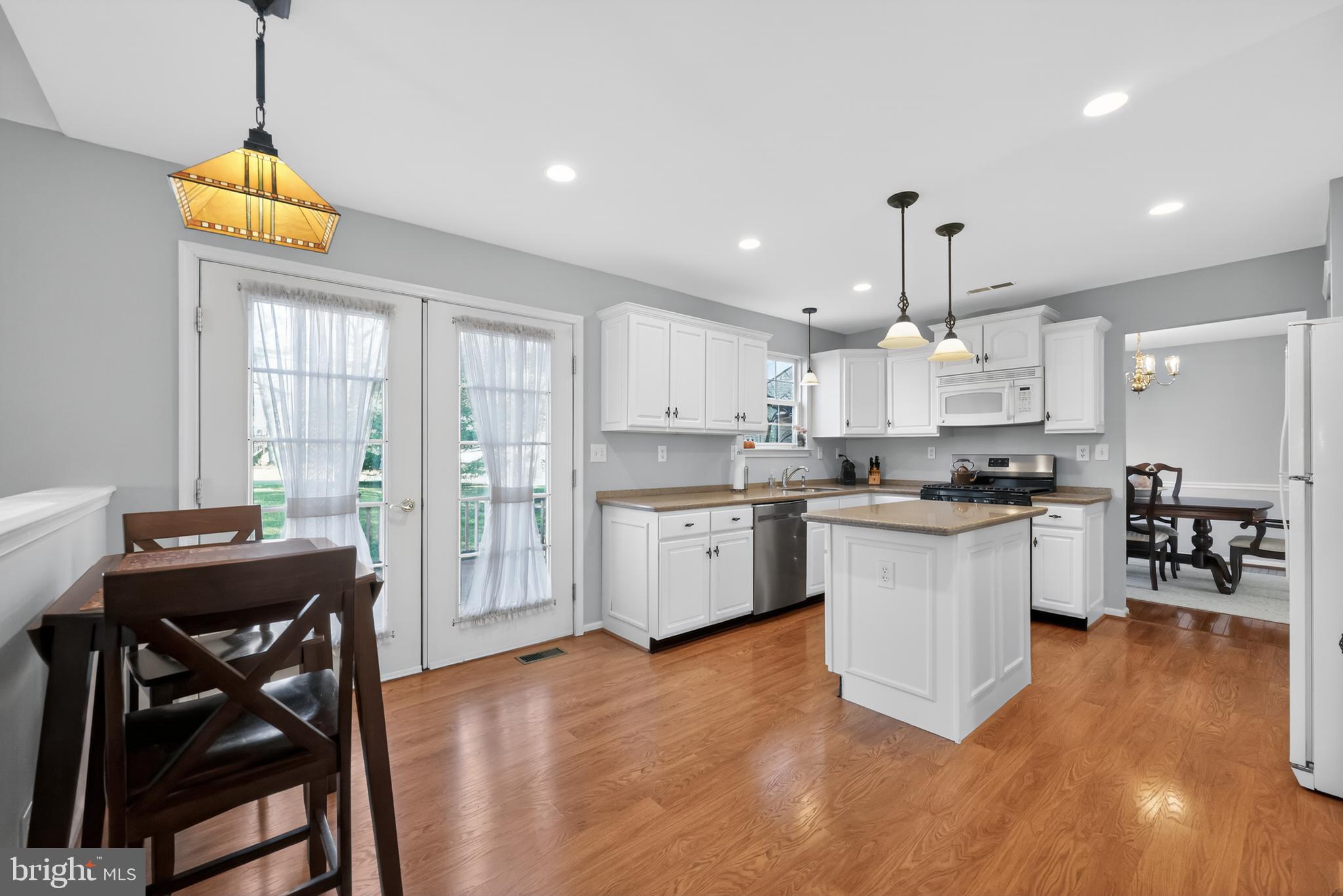 25 Country Lane Voorhees, NJ 08043 - Photo 3 of 36 a kitchen with stainless steel appliances kitchen island granite countertop a stove a sink a refrigerator and white cabinets with wooden floor