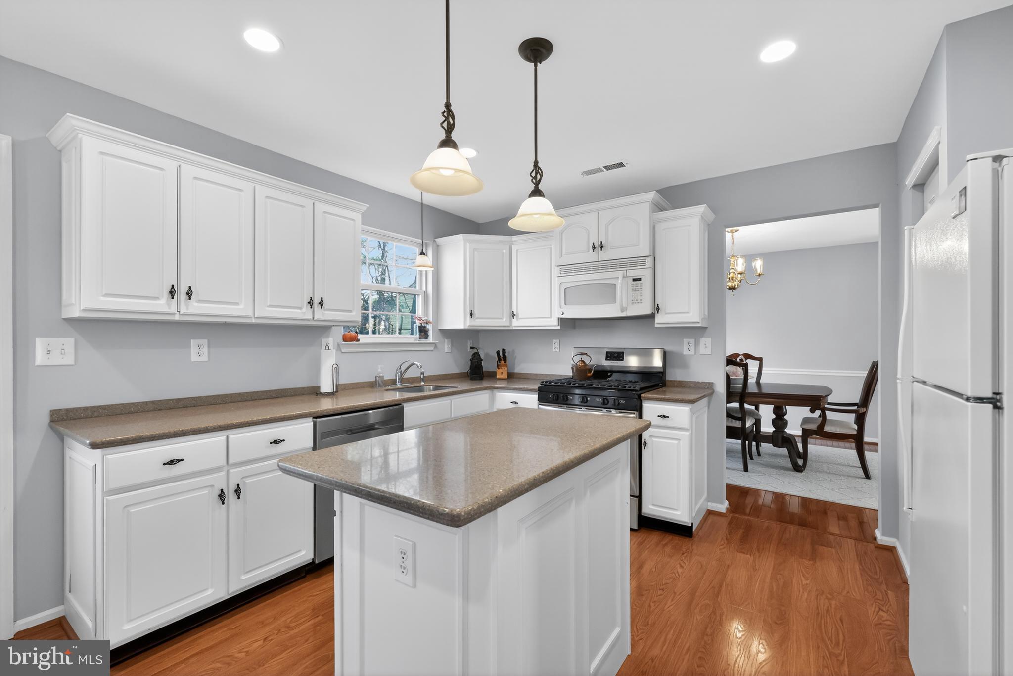 25 Country Lane Voorhees, NJ 08043 - Photo 4 of 36 a kitchen with a center island white cabinets and stainless steel appliances