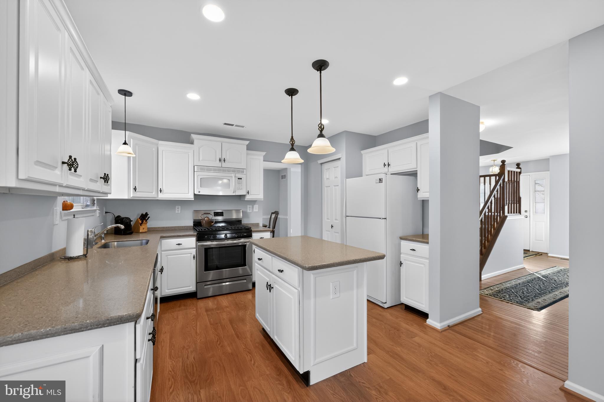 25 Country Lane Voorhees, NJ 08043 - Photo 5 of 36 a kitchen with stainless steel appliances kitchen island granite countertop a refrigerator a stove a sink and white cabinets with wooden floor