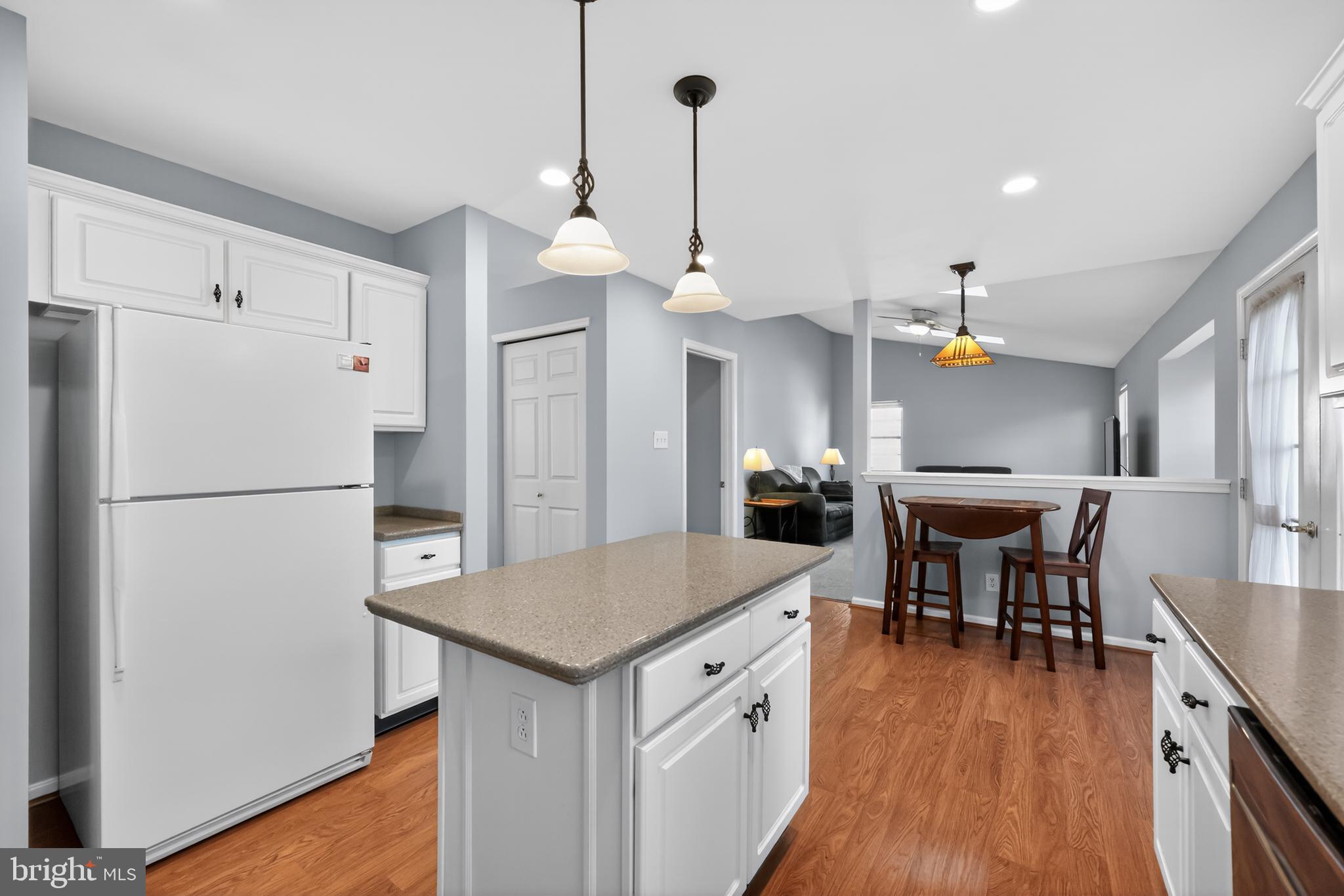 25 Country Lane Voorhees, NJ 08043 - Photo 6 of 36 a kitchen with stainless steel appliances a refrigerator a stove a dining table and chairs with wooden floor