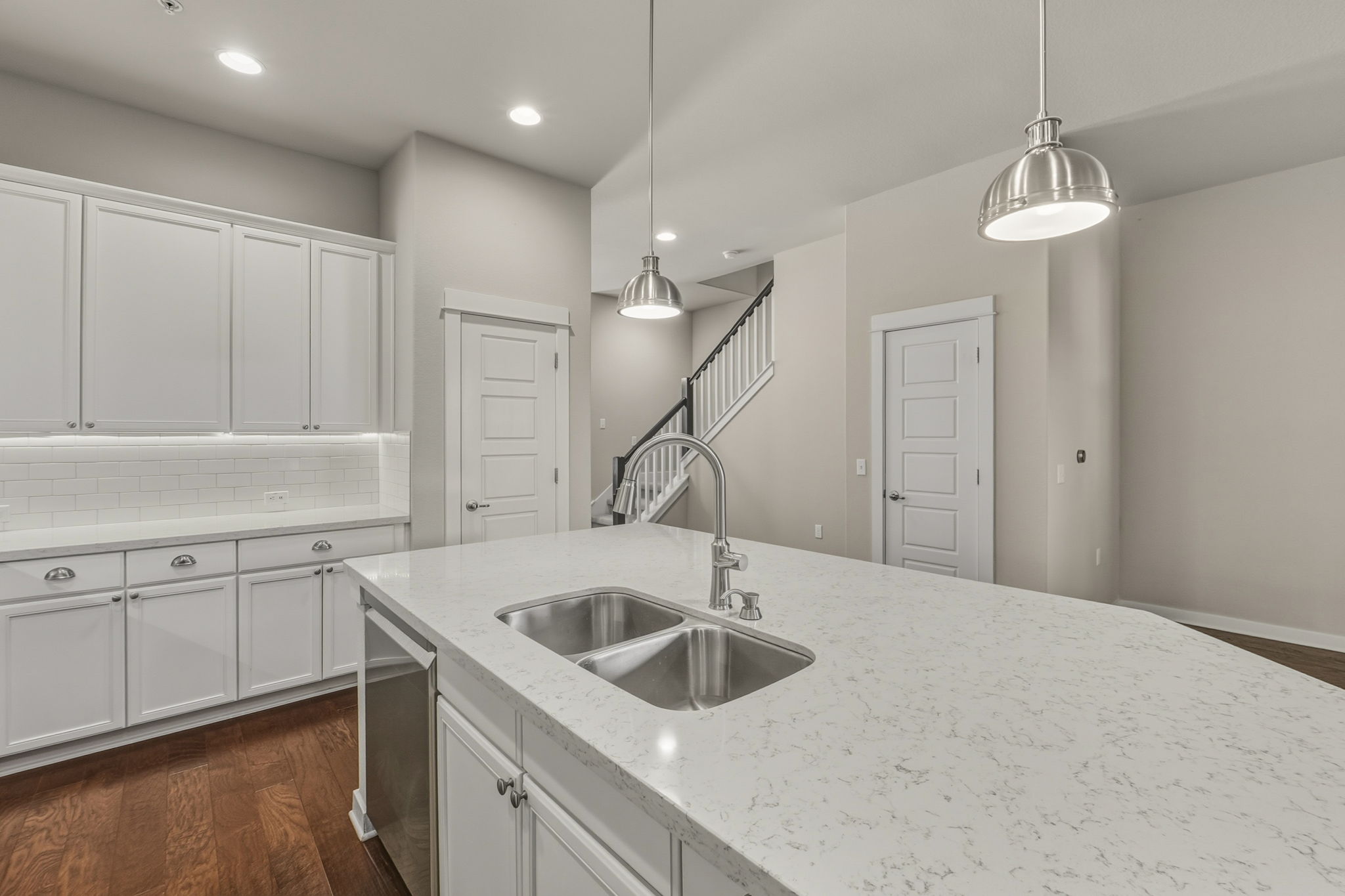 3919 Vaughan Street Austin, TX 78723 - Photo 13 of 40 A contemporary kitchen features a spacious island with dual sinks and recessed lighting overhead.