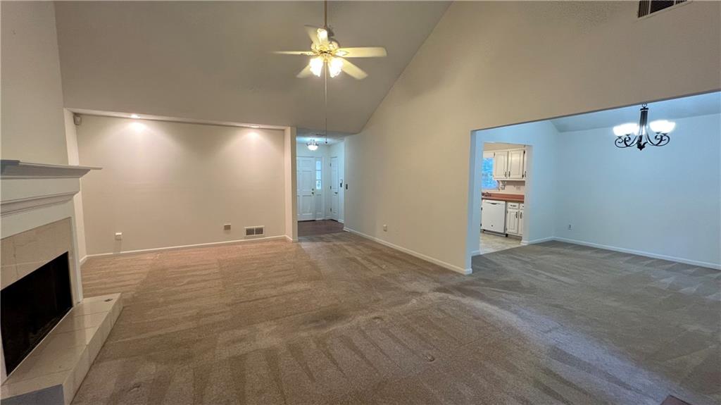 995 Old Spring Way Northeast Sugar Hill, GA 30518 - Photo 11 of 36 a view of a livingroom with a fireplace a chandelier fan and windows
