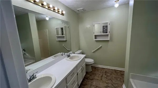 a bathroom with a sink a toilet and mirror