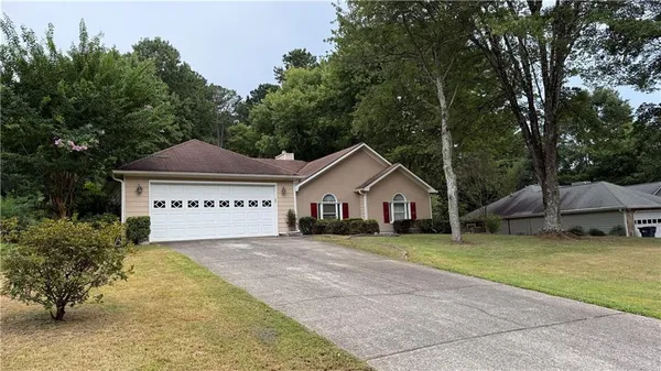 a view of a house with a yard and large trees