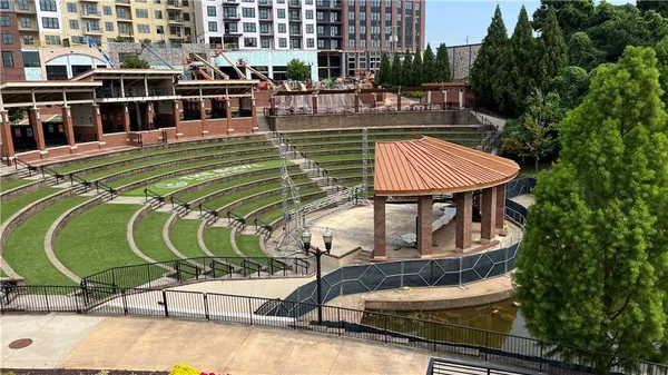 a view of swimming pool with seating area and trees in the background