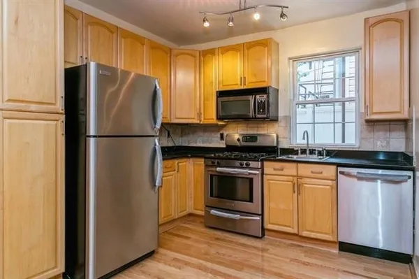 a kitchen with granite countertop a refrigerator stove and microwave