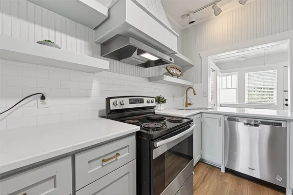 a kitchen with granite countertop stainless steel appliances and wooden floor