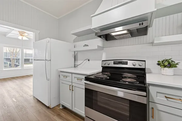 a kitchen with appliances a counter space and wooden floor