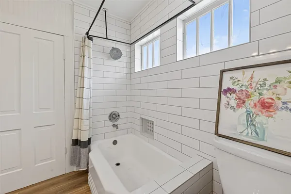 a bathroom with a white bath tub and a shower