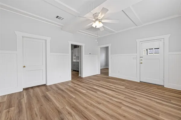 a view of a livingroom with wooden floor and a ceiling fan