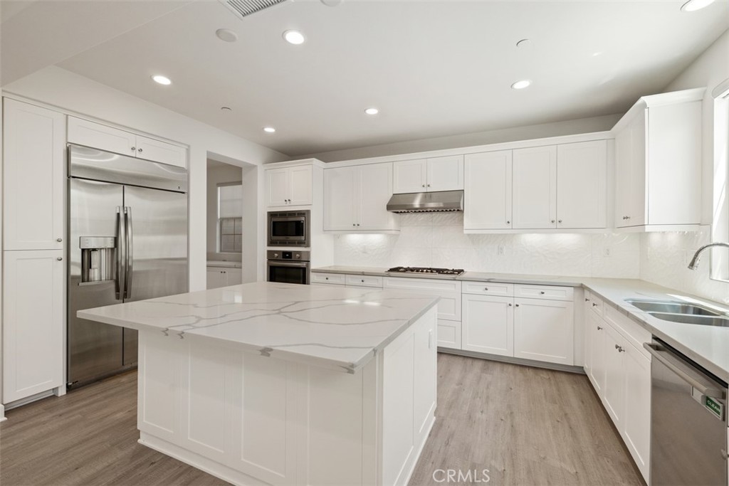 116 Windswept Irvine, CA 92618 - Photo 12 of 74 a kitchen with stainless steel appliances granite countertop a sink a stove a refrigerator and cabinets