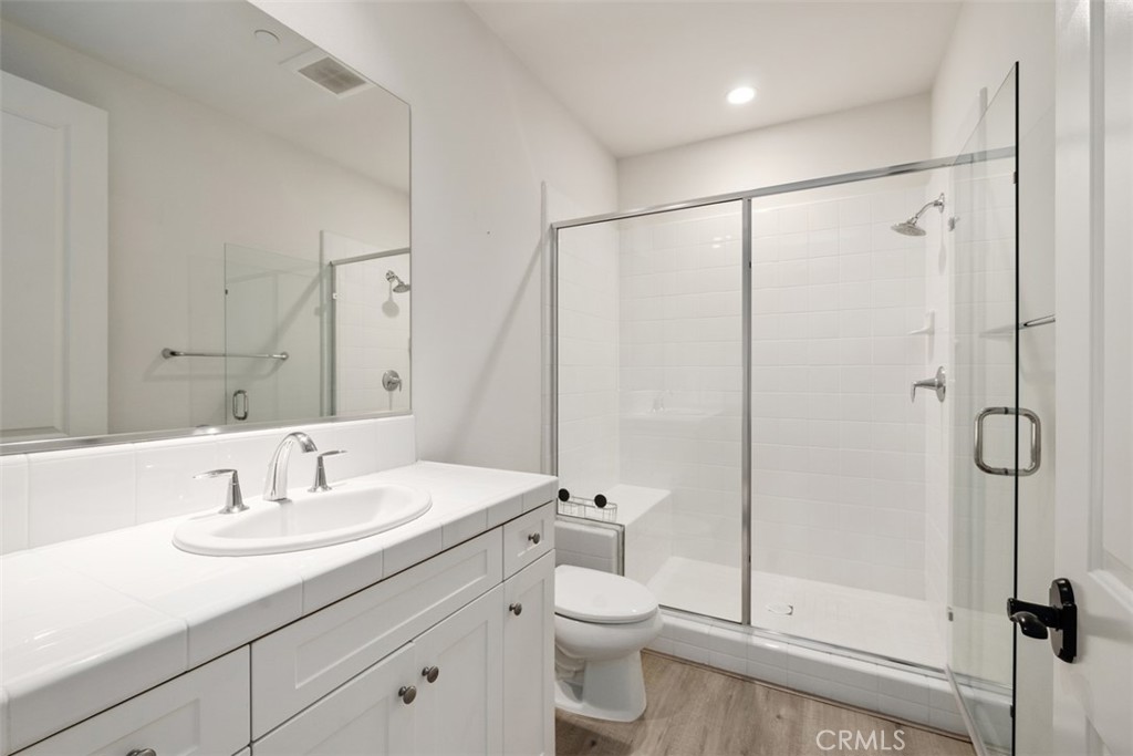 116 Windswept Irvine, CA 92618 - Photo 20 of 74 a bathroom with a shower sink vanity mirror and toilet