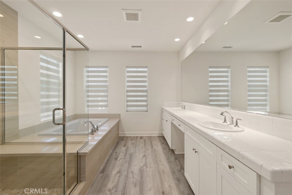 116 Windswept Irvine, CA 92618 - Photo 27 of 74 a spacious bathroom with a double vanity sink a mirror and a bathtub