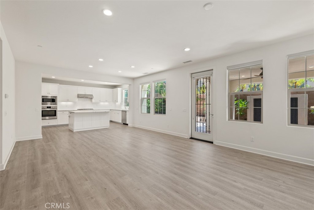 116 Windswept Irvine, CA 92618 - Photo 5 of 74 a view of an empty room with a window and wooden floor