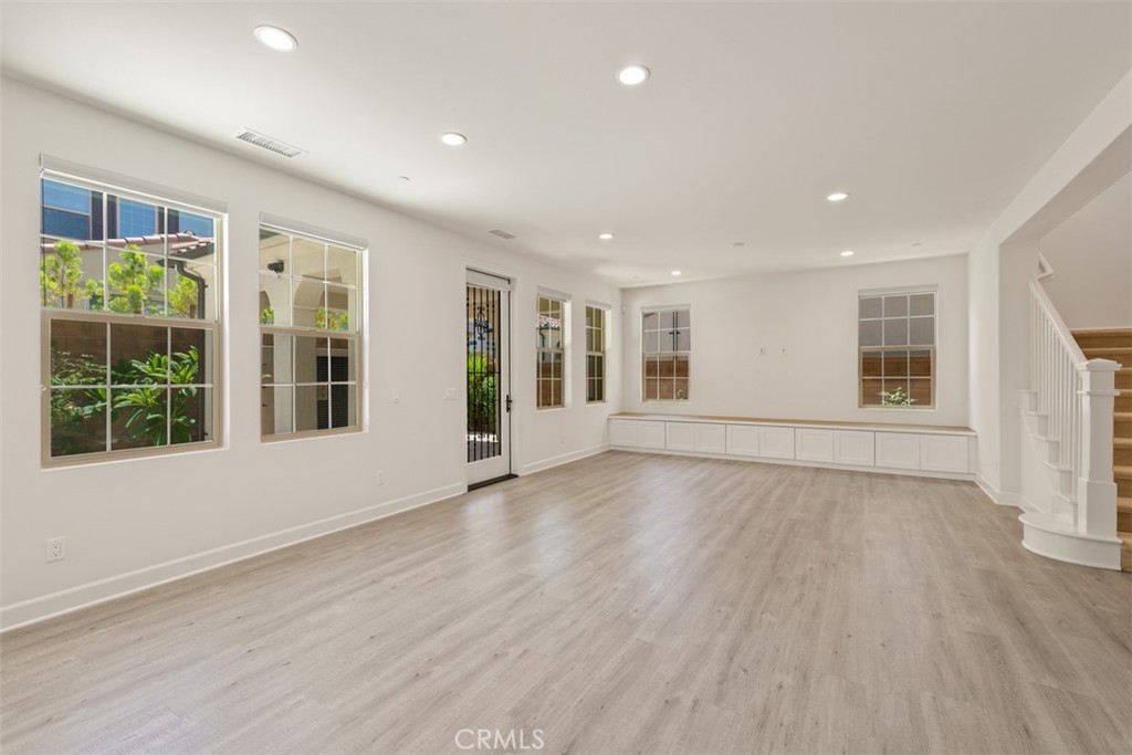 116 Windswept Irvine, CA 92618 - Photo 6 of 74 a view of an empty room with wooden floor and windows