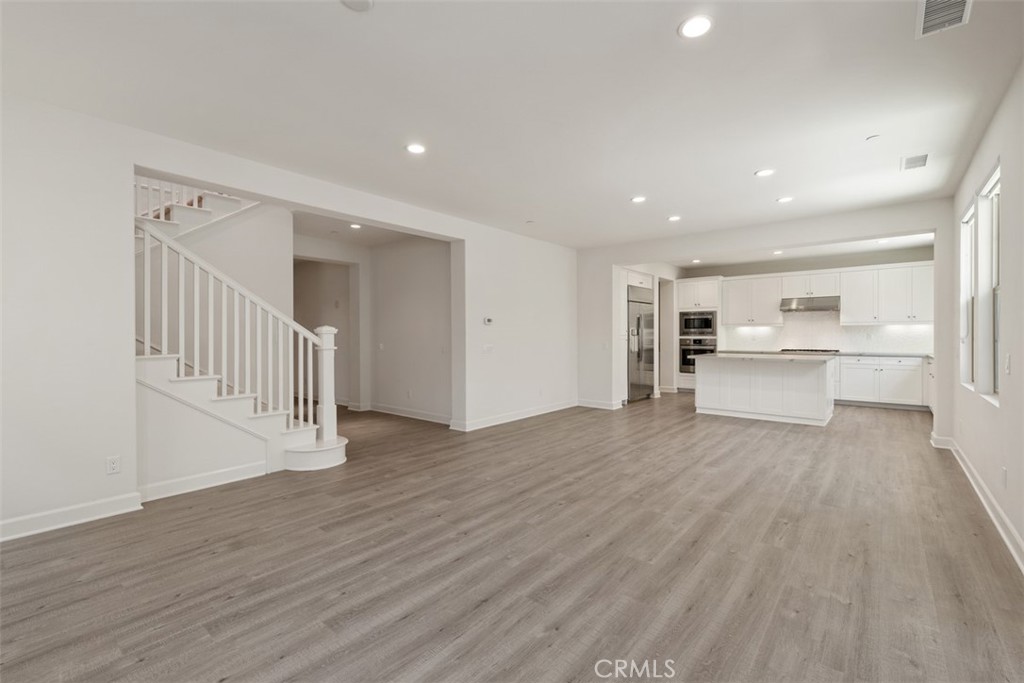 116 Windswept Irvine, CA 92618 - Photo 9 of 74 a view of a hallway with wooden floor kitchen view and a window