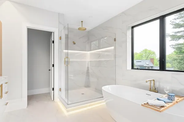 a bathroom with a tub shower and window